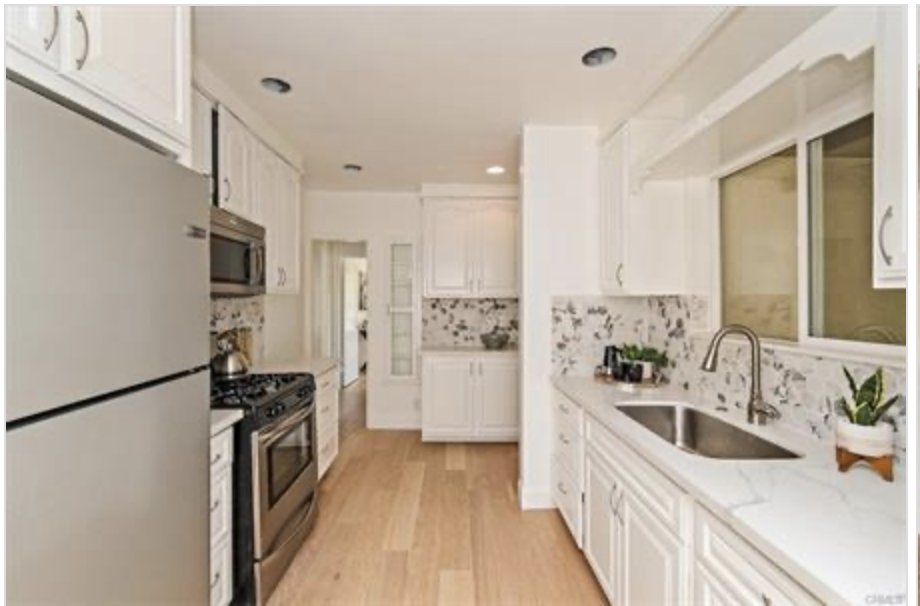 Kitchen after renovation — bright white, quartz counters